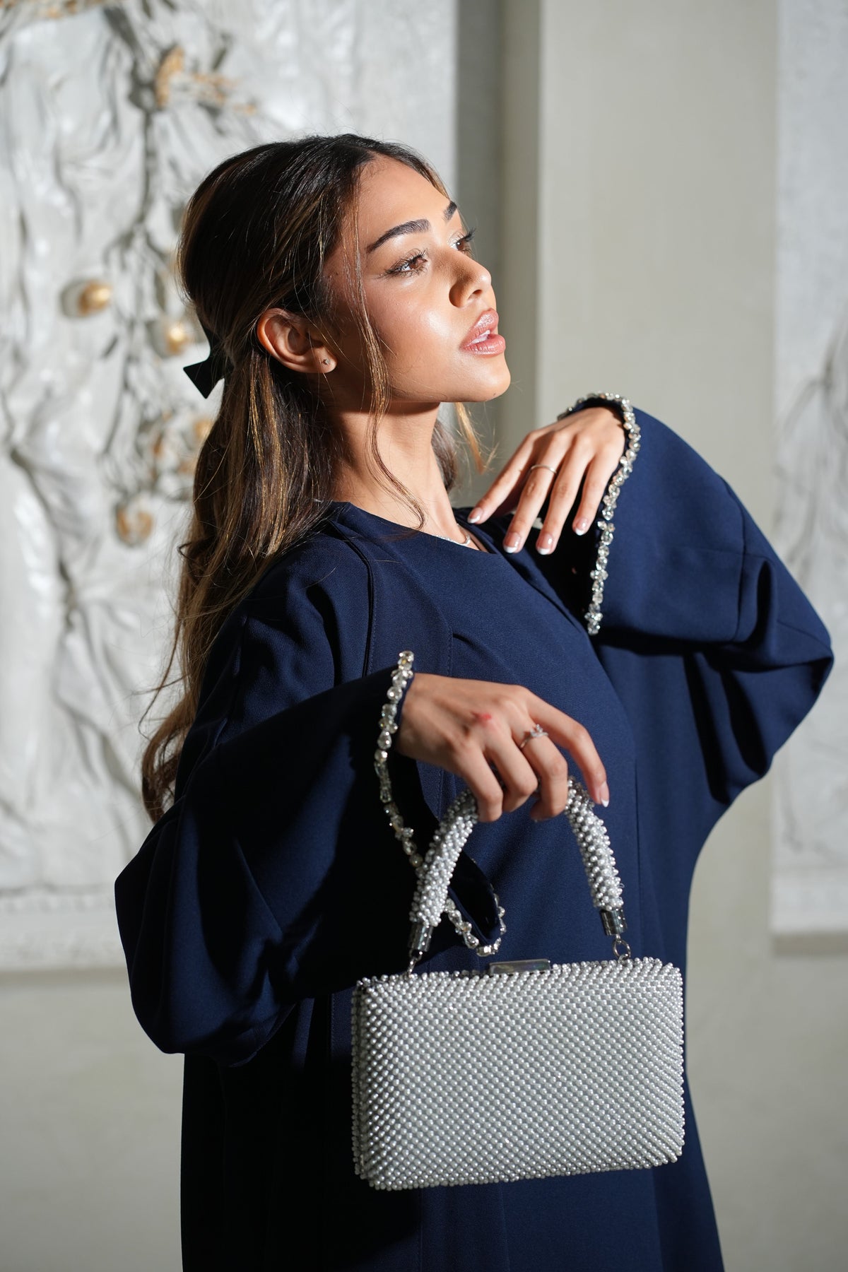 Navy abaya with crystal cuffs, worn with a pearl bag